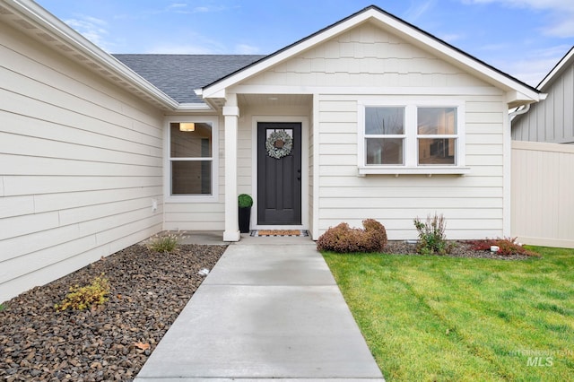 view of exterior entry with a lawn