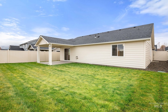 rear view of property with a lawn and a patio area