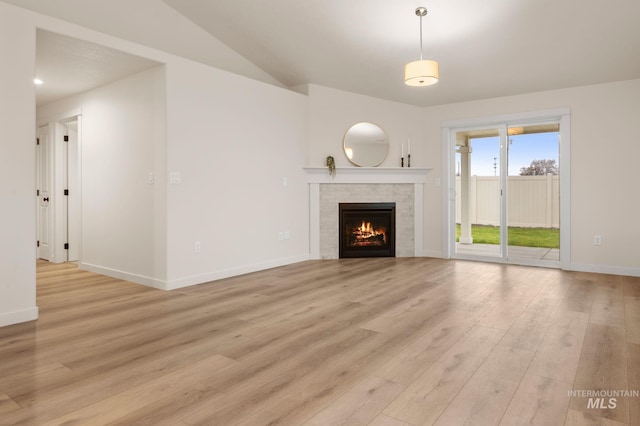 unfurnished living room featuring light hardwood / wood-style floors and a tiled fireplace