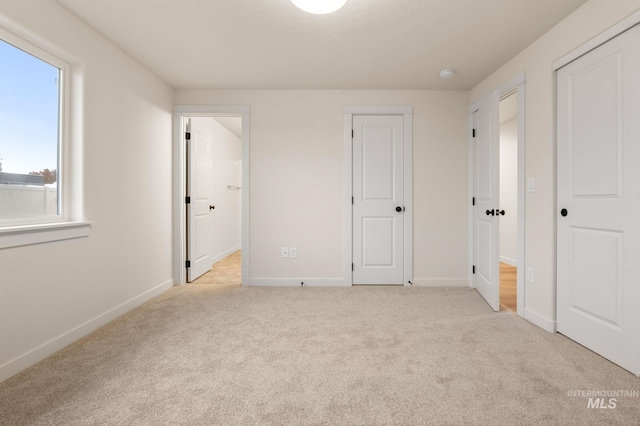 unfurnished bedroom featuring light carpet