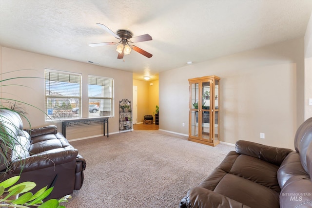 carpeted living room with a textured ceiling, a ceiling fan, visible vents, and baseboards