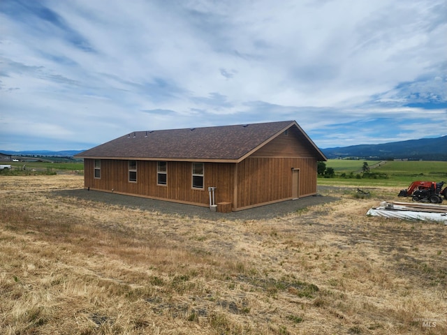 view of side of home with a mountain view and a rural view