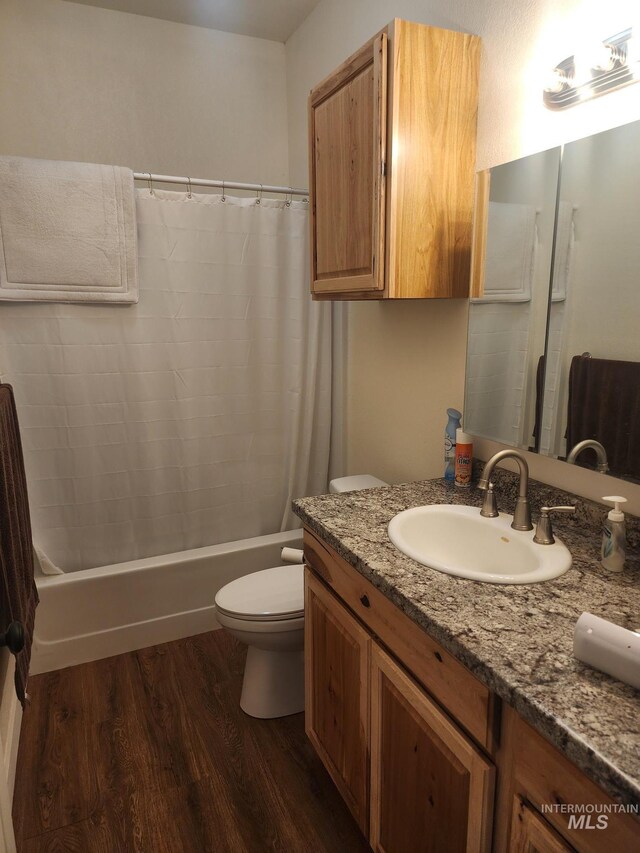 full bathroom with shower / tub combo, toilet, hardwood / wood-style floors, and vanity