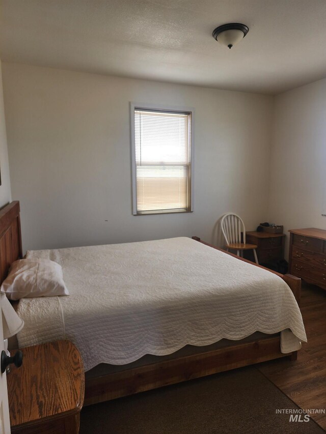 bedroom with dark hardwood / wood-style floors