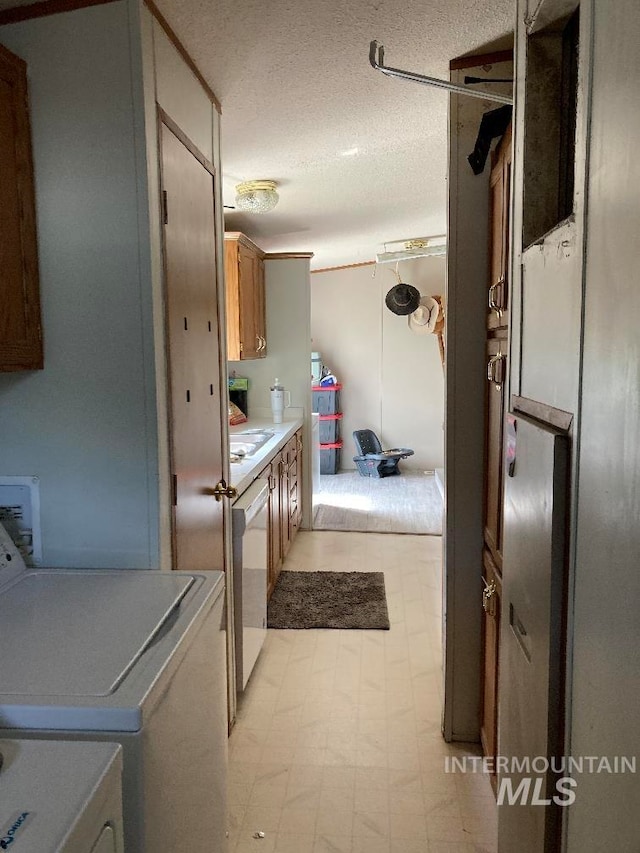 776 16th St, Vale, OR 97918 - washroom with a textured ceiling, separate washer and dryer, and light flooring