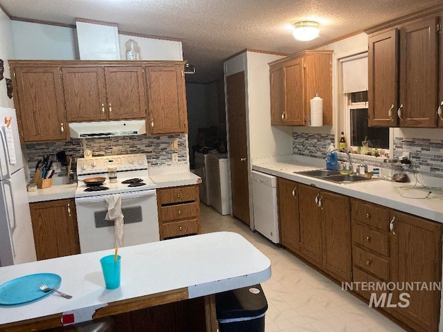 776 16th St, Vale, OR 97918 - kitchen with white appliances, a sink, extractor fan, washer and dryer, and decorative backsplash