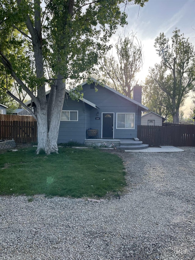 640 Roosevelt Ave, Grand View, ID 83624 - view of front of house with fence, a front lawn, and a chimney