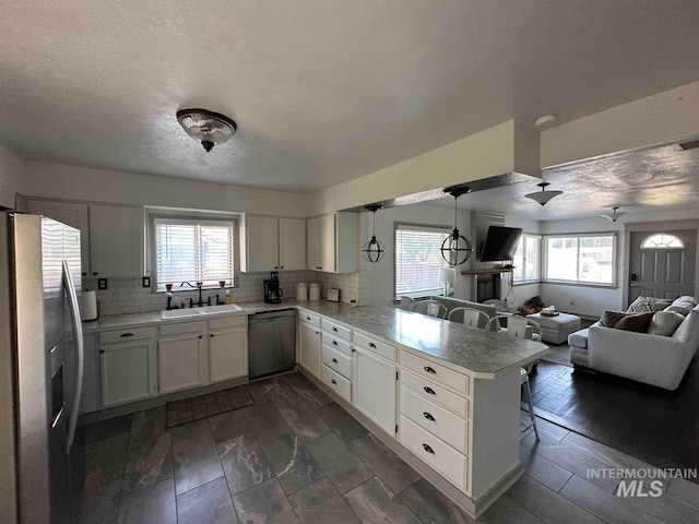 640 Roosevelt Ave, Grand View, ID 83624 - kitchen with a peninsula, appliances with stainless steel finishes, plenty of natural light, and a sink