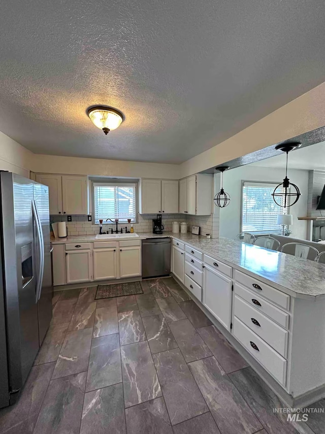 640 Roosevelt Ave, Grand View, ID 83624 - kitchen featuring a peninsula, light countertops, stainless steel appliances, and tasteful backsplash