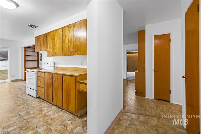 kitchen with light countertops, brown cabinetry, visible vents, and white range with electric cooktop