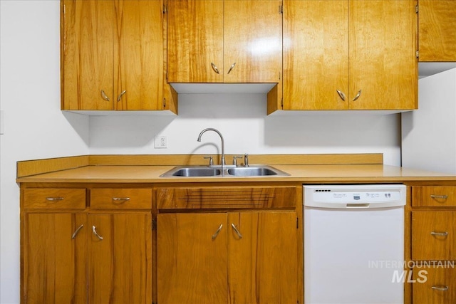 kitchen with dishwasher, light countertops, brown cabinetry, and a sink