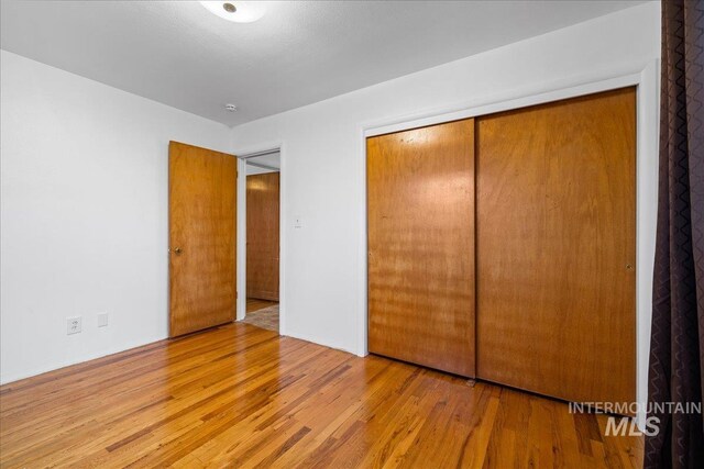 unfurnished bedroom featuring a closet and wood finished floors