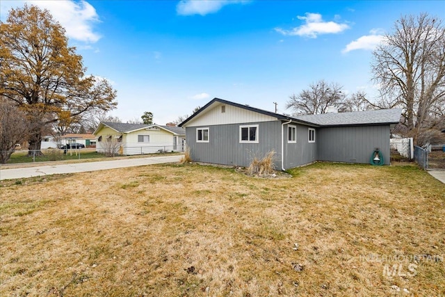 rear view of house with a yard and fence