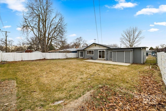 rear view of house with a patio area, a fenced backyard, and a lawn