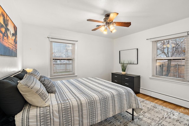 92 N Yale St, Nampa, ID 83651 - bedroom with light wood-type flooring, a ceiling fan, and a baseboard heating unit