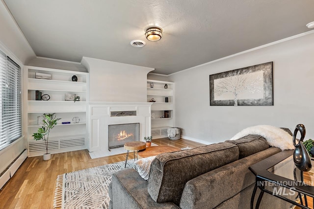 92 N Yale St, Nampa, ID 83651 - living room with visible vents, light wood finished floors, a fireplace with flush hearth, and crown molding
