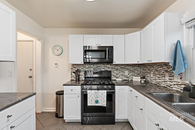 92 N Yale St, Nampa, ID 83651 - kitchen featuring dark countertops, stainless steel appliances, decorative backsplash, and white cabinetry