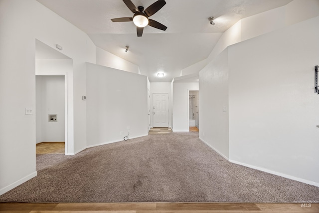 unfurnished room with vaulted ceiling, a ceiling fan, baseboards, and carpet floors