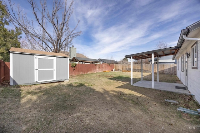 view of yard with a patio area, a storage unit, an outbuilding, and a fenced backyard