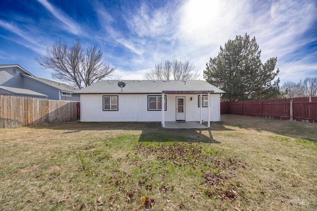 back of property featuring a patio area, a yard, and a fenced backyard