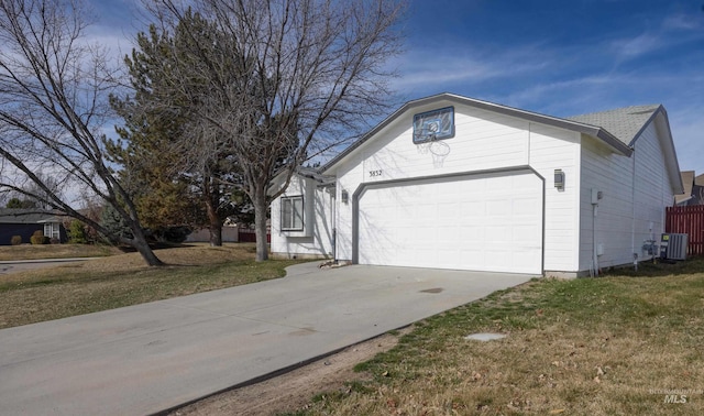 view of front of property featuring a front yard, an attached garage, driveway, and central AC