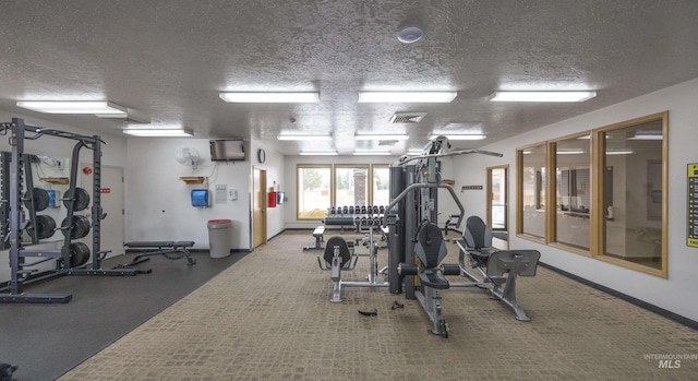 gym featuring visible vents, baseboards, and a textured ceiling