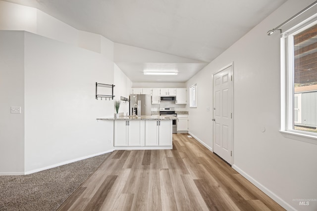 kitchen featuring light wood-type flooring, white cabinetry, stainless steel appliances, a peninsula, and baseboards