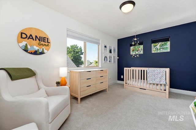 bedroom featuring a crib and light carpet