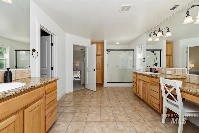 bathroom with tile patterned floors, vanity, and an enclosed shower