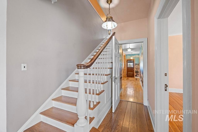 stairs featuring baseboards and hardwood / wood-style floors