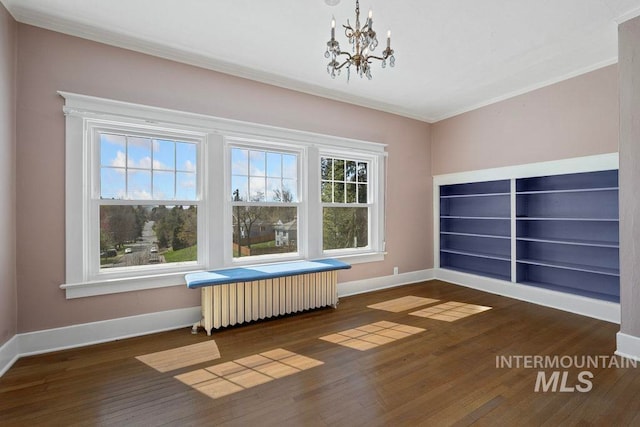 interior space with baseboards, a chandelier, crown molding, wood finished floors, and radiator heating unit