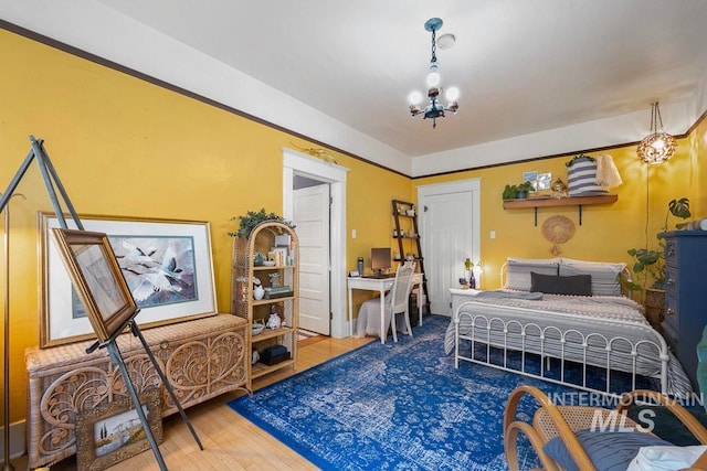 bedroom with a chandelier and wood finished floors