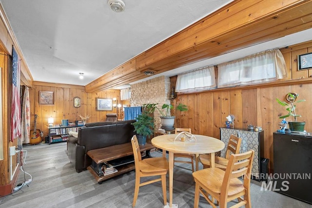 dining space with wood finished floors and wood walls