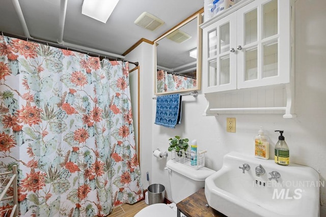 full bathroom with a sink, visible vents, toilet, and a shower with shower curtain