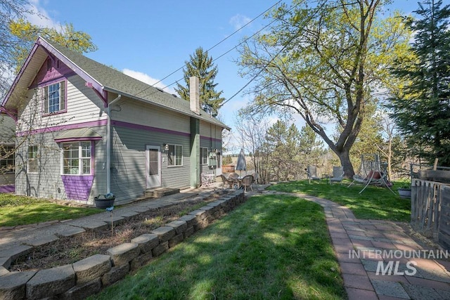 view of side of home featuring a yard and a chimney