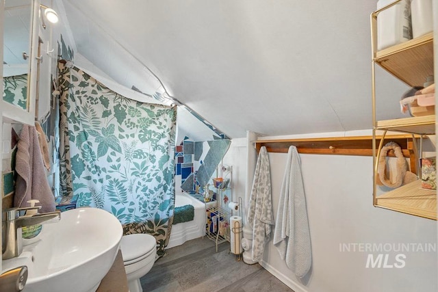 bathroom with shower / bath combo, a sink, toilet, and wood finished floors