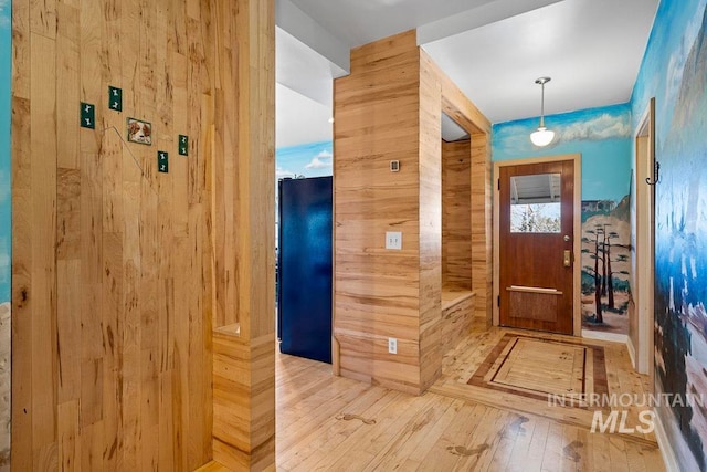 foyer entrance featuring wood walls and wood-type flooring