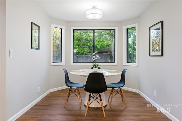 dining room featuring dark wood-type flooring and baseboards