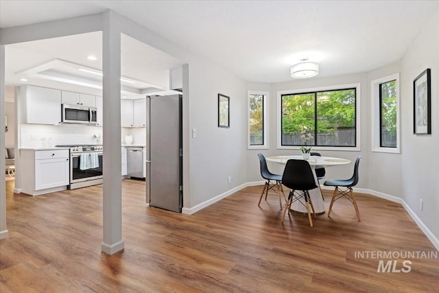 dining room with baseboards, recessed lighting, and light wood-style floors