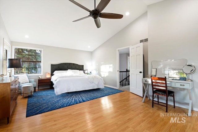 bedroom with visible vents, light wood-style flooring, multiple windows, and high vaulted ceiling