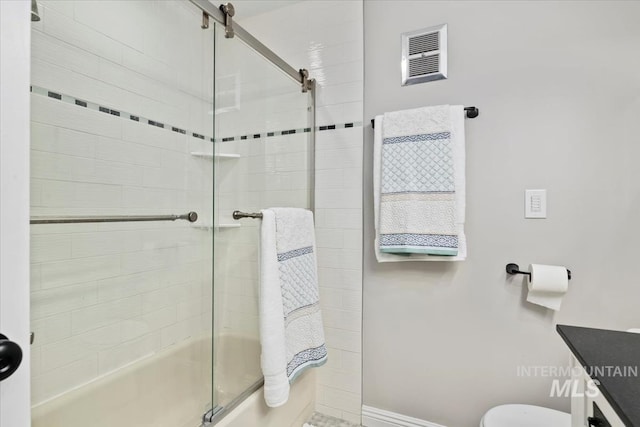 bathroom with visible vents, toilet, tiled shower / bath combo, and baseboards