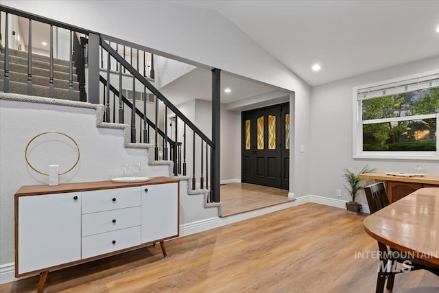 entryway with stairway, baseboards, recessed lighting, vaulted ceiling, and wood finished floors