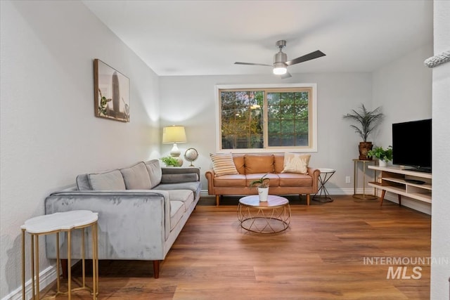 living room with ceiling fan, wood finished floors, and baseboards