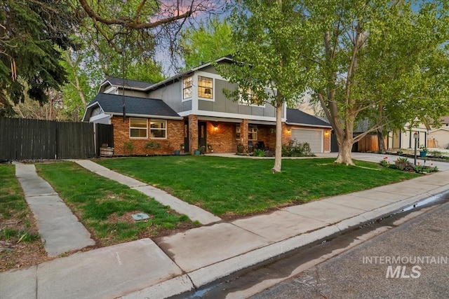 traditional-style house with a garage, brick siding, fence, and a lawn
