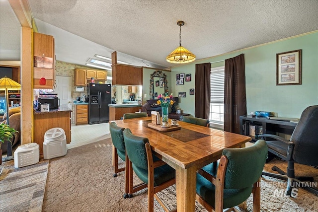 dining area with lofted ceiling, a textured ceiling, light colored carpet, and an inviting chandelier