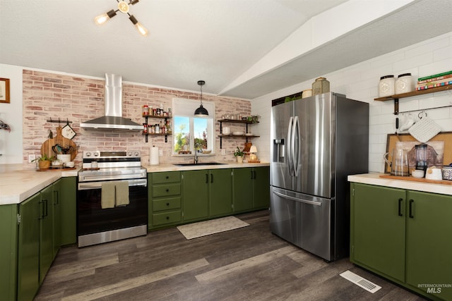 5950 Elmore Rd, New Plymouth, ID 83655 - kitchen featuring appliances with stainless steel finishes, wall chimney exhaust hood, green cabinetry, open shelves, and lofted ceiling