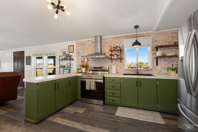 5950 Elmore Rd, New Plymouth, ID 83655 - kitchen with wall chimney range hood, appliances with stainless steel finishes, green cabinetry, a peninsula, and a textured ceiling