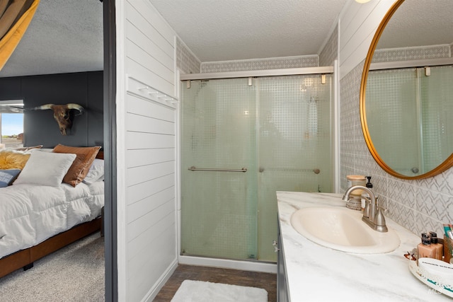 5950 Elmore Rd, New Plymouth, ID 83655 - bathroom with ensuite bathroom, a stall shower, a textured ceiling, vanity, and wood finished floors
