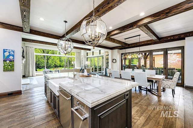 kitchen featuring baseboards, a sink, a chandelier, and hardwood / wood-style floors