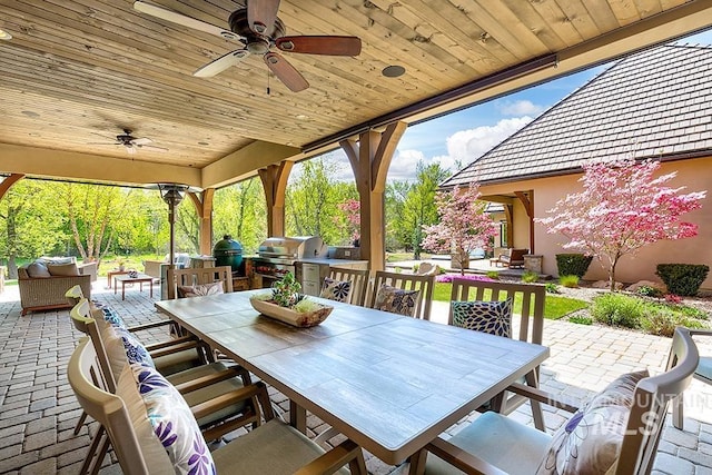 view of patio / terrace featuring a ceiling fan, outdoor dining space, exterior kitchen, and a grill